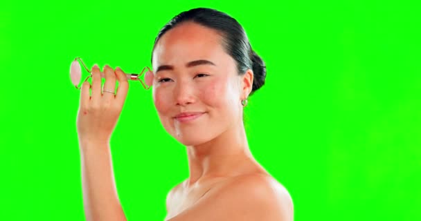 背景のモックアップに隔離されたスタジオで緑の画面上のローラーで顔 美容スキンケアとアジアの女性 皮膚科 顔と肌の治療のためのローズクォーツ石と幸せな女性モデル — ストック動画