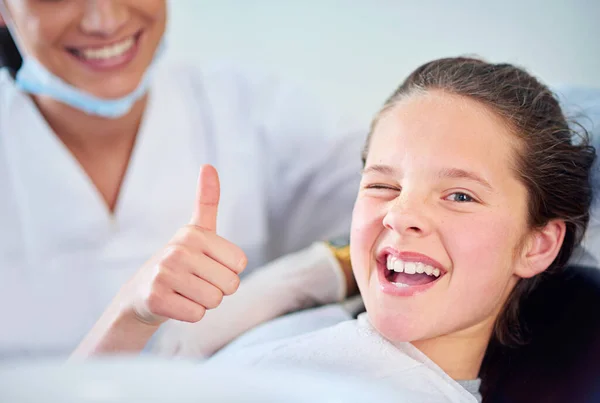 在热座位上 一个年轻女孩坐在牙医椅子上竖起大拇指的画像 — 图库照片