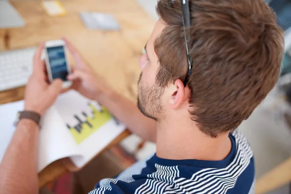 必要な技術で作業する 携帯電話の情報を見ている若い男の肩の上にトップビュー — ストック写真