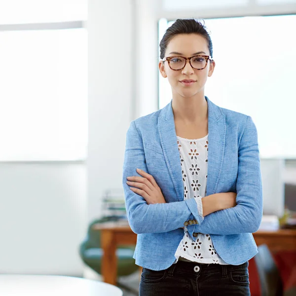 Focused on her career goals. Portrait of a young woman standing with her arms crossed in an office