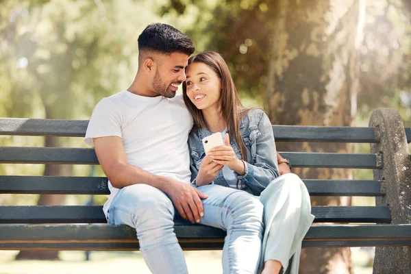 幸せなカップル 公園のベンチでリラックスして一緒に自然界のソーシャルメディアや結合を参照してください 夏のアウトドアで携帯電話の関係のための幸福の男と女の笑顔 — ストック写真