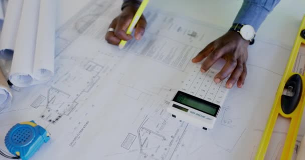 建築家の計算機 青写真や人の手のインフラストラクチャ フロアプランやプロパティプロジェクト番号を計算します 建築工学 建築測定を書くアフリカ人 — ストック動画