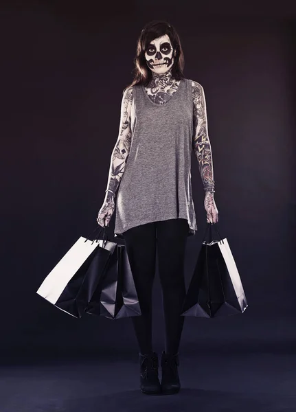 ハッピーハロウィンショッピング 彼女の顔に描かれた伝統的なカラベラスの死のマスクを持つ女性 ショッピングバッグと — ストック写真