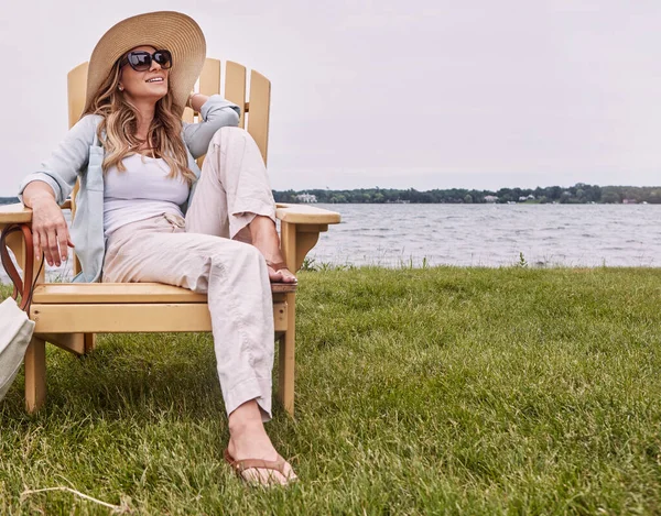 每天增加一点闲暇时间 一位年轻貌美的女子坐在湖边的椅子上休息 — 图库照片