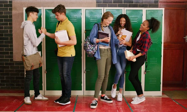 stock image See you later buddy. a group of cheerful young school kids talking to each other before class inside of a school during the day
