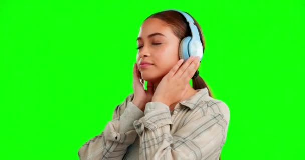 スタジオの背景ラジオで隔離された音楽を聴いている緑の画面 ヘッドフォンや女性は 踊りと穏やかな モックアップ空間上のストリーミングサービスプロモーションのためのオーディオ技術とGen Z人のダンス — ストック動画