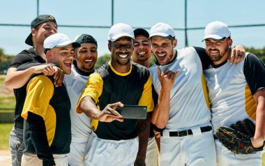 Theres time for home runs then theres time for selfies. a team of young baseball players staking a selfie together while standing on the field during the day clipart