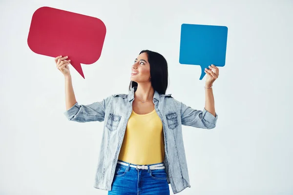 Lets chat. Studio shot of an attractive young woman holding speech bubbles