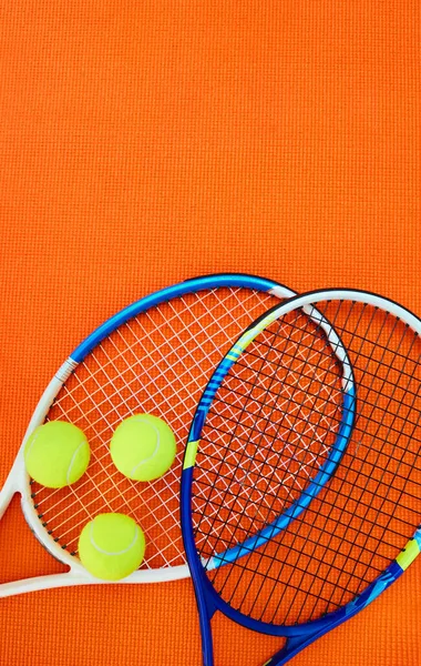 彼らは一緒にいることを意味します スタジオ内のオレンジの背景の上に配置されたテニス必需品の高角度ショット — ストック写真