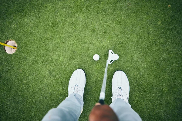 Grass, golf hole and man with club on course for game, practice and training for golfing competition. Professional golfer, sports and top view of male shoes hit ball for winning, score or tee stroke.