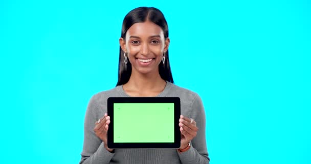 绿色屏幕和一个女人的脸 她的平板电脑被隔离在工作室的蓝色背景上 一个印度女孩的模仿 微笑和肖像 她拿着技术 用一块空白的屏幕做广告 — 图库视频影像