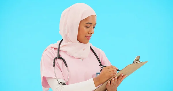 医師や情報や医療記録のためのスタジオでクリップボードに書き込みます 青の背景に医療保険のためのリストとヒジャーブのイスラムまたはイスラム教徒の女性と専門看護師 — ストック写真