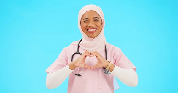 护士和穆斯林妇女与心脏的手在工作室孤立的蓝色背景模型 肖像和快乐的医学专业人员或具有感情或爱心和关怀象征的伊斯兰人士 — 图库照片