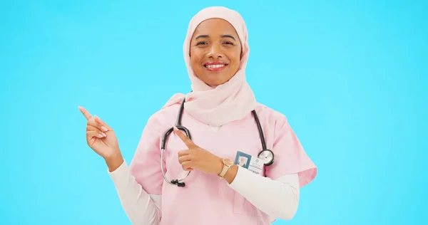 医療プレゼンテーションや製品の配置スペースのための青の背景に隔離されたモックアップを指す女性医師 看護師や医療イスラム教徒の人の幸せな顔はスタジオで宣伝モックアップを表示 — ストック写真