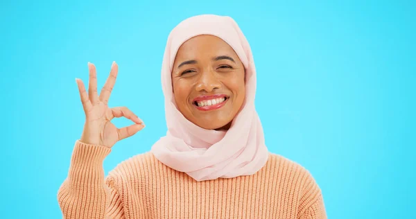 絵文字 アイコンや合意のための手で顔にイスラム教徒の女性 Okサインや笑顔 スタジオブルーの背景に感謝 サポートと合意または承認のためのヒジャーブとシンボルを持つイスラム女性 — ストック写真