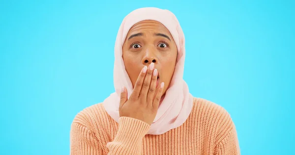 穆斯林妇女 带着惊讶和惊讶手拉手模仿 做广告或促销 带有头巾和面部表情的伊斯兰女性 因在工作室蓝色背景下对销售 流言蜚语或秘密做出反应 — 图库照片