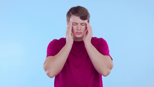 生病了 男人和头痛的疼痛在工作室 蓝色背景和头晕的压力 精神健康和脑雾 可悲的男模 偏头痛 精疲力尽焦虑 沮丧和抑郁 — 图库视频影像