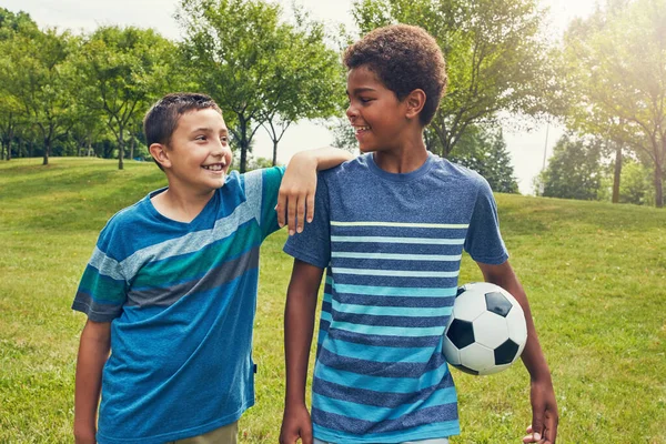 通过对游戏的热爱结合在一起 两个小男孩在公园里踢足球 — 图库照片