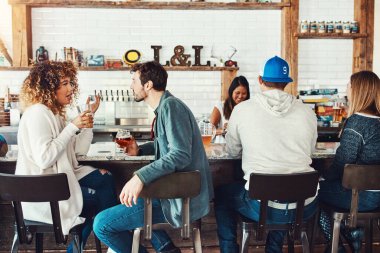 Bunu mu yoksa şunu mu tercih edersin? Gençler barda içki içiyorlar.