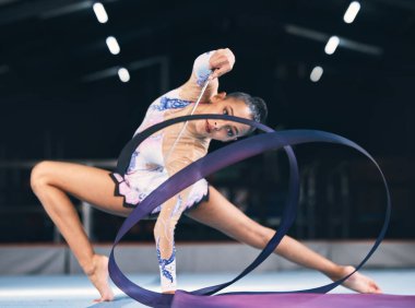 Esnek kadın, kurdele jimnastiği ve performans, spor müsabakası ve aksiyon gösterisi dansçısı. Kadın, ritmik hareket ve yaratıcı yeteneği, dengesi ve çevikliğiyle dans eden bir atlet..