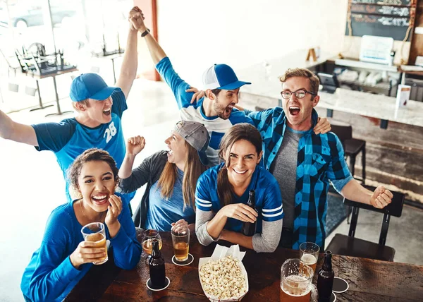 偉大なゲーム 偉大な会社 バーでスポーツの試合を見ながら応援する仲間たち — ストック写真