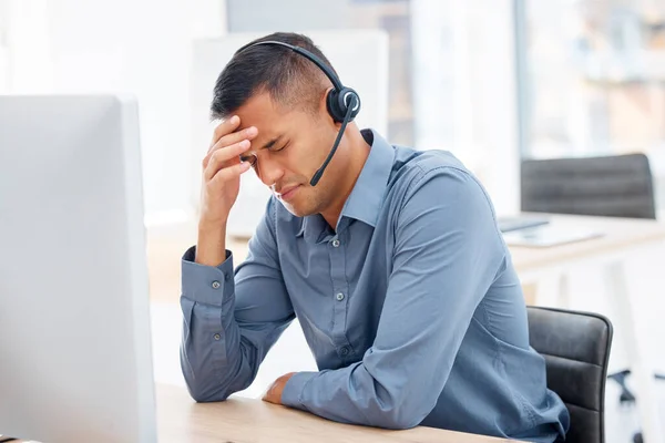 Headache, migraine pain or man in call center with burnout feeling overworked in crm communication. Stressed, office or tired telemarketing sales agent with anxiety, fatigue or mental health problems.