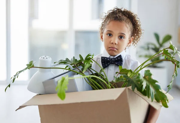 Sad, portrait and a child playing as a business person with a box of belongings after fired. Unhappy, jobless and a little girl pretending to leave an office and packing after work retrenchment.