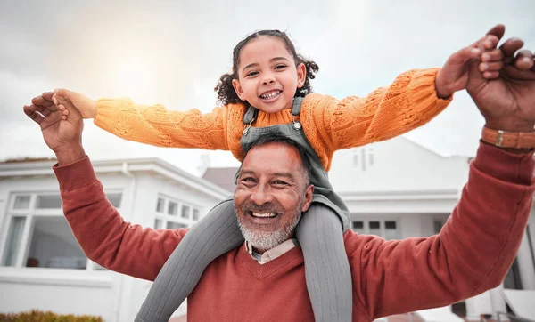 Shoulder hug and portrait of grandfather and girl for bonding, playful and affectionate. Weekend, free time and happiness with family on lawn at home for support, care and holiday together.