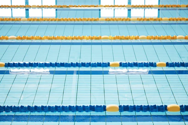 Empty, swimming pool or lines in water for competition or racing lanes for fitness or underwater sports. Background, blue or training arena ready for race performance, workout or exercise challenge.