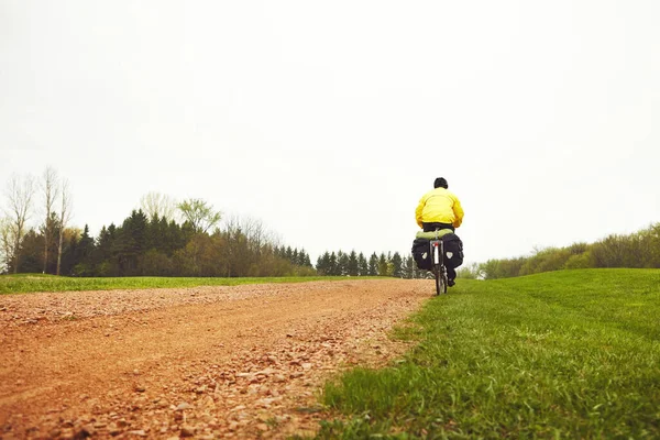 stock image An early morning cycle to get the blood pumping. Rearview shot of a male cyclist enjoying a bike ride on a wet winters morning