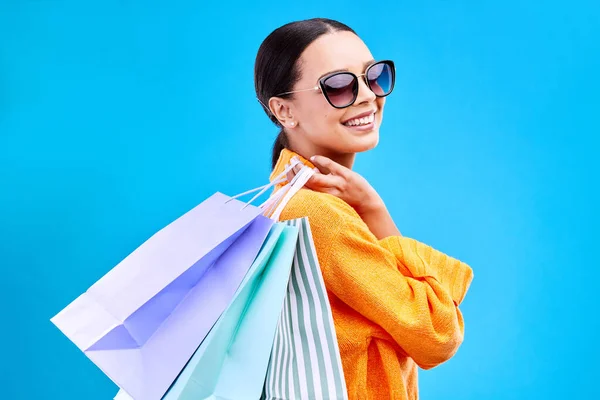 ショッピングバッグは ブティック販売から笑顔と幸福とスタジオと女性の肖像画を扱います ハッピー 顧客とサングラスで隔離された青の背景で店のバッグと販売と女性モデル — ストック写真