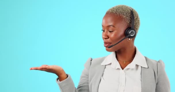 スタジオでカスタマーサポート セールス 製品の話をする手 ヘッドセット コールセンターの女性 青色の背景にテレマーケティングや広告のモックアップのために働く黒人女性エージェントやコンサルタント — ストック動画