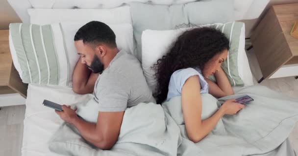 ベッドのカップルとオーバーヘッドは ソーシャルメディアに気を取られ お互いを無視しています 戦いや問題の後に家に横たわっている男と女とインターネット 寝室や不正行為 — ストック動画