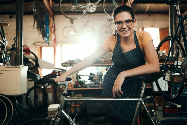 自行车行业中最好的 在自行车修理店工作的一位年轻妇女的画像 — 图库照片