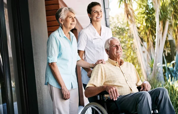 不管他们的处境如何 都要保持积极 一对老年夫妇和一个养老院外的护士 — 图库照片
