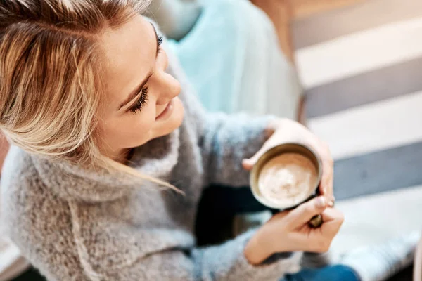 stock image Downtime done right. a young woman relaxing on the sofa at home with a warm beverage