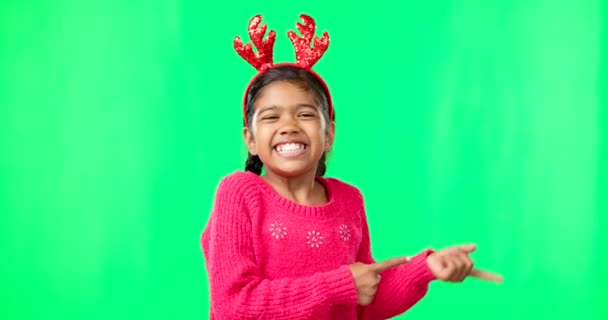 儿童肖像画 圣诞节和指向绿色屏幕上的手指枪 在工作室背景上对着一个女孩的脸微笑 带着鹿角头带参加节日庆祝活动 用手模仿空间 — 图库视频影像