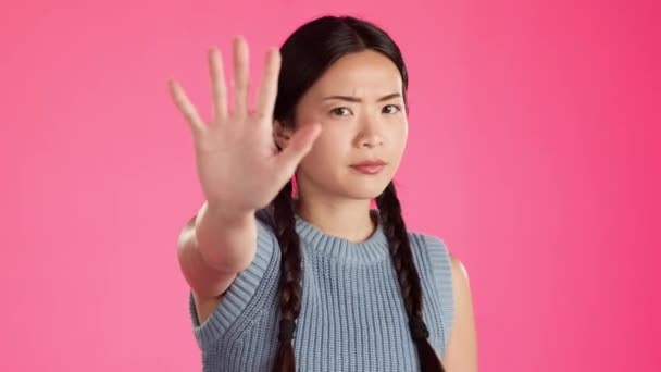 抗議闘争 女性のエンパワメントのための投票や警告のためにピンクの背景にスタジオで隔離されたアジアの女性 顔や停止手 肖像画 手のひらと人種差別や不平等へのジェスチャー — ストック動画