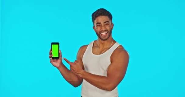 绿色屏幕和男人与手机指向工作室孤立的蓝色背景 快乐的印度男性的手机 肖像和微笑 通过广告 营销或产品投放模型 — 图库视频影像