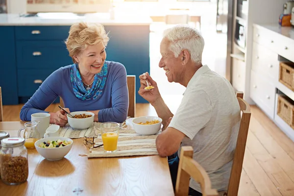 退休做得很好 一对快乐的成熟夫妇在家里的厨房里一起吃早餐 — 图库照片