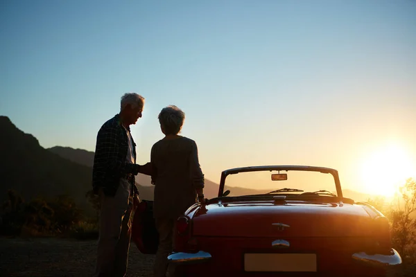 stock image Living the life theyve always dreamed of. an affectionate senior couple enjoying the sunset during a roadtrip