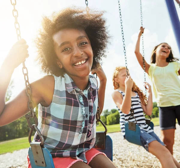 一緒に楽しい時間を過ごす 彼女の友人と公園でスイングで遊んでいる若い女の子の肖像画 — ストック写真