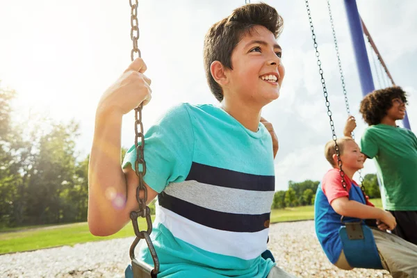 子どもたちは遊びを通して自信と意識を養います 公園でブランコに乗って遊ぶ少年たち — ストック写真