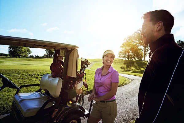 stock image Hitting the greens with his girl. a couple playing golf together on a fairway