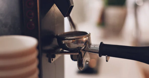 Coffee machine, barista hand and grind beans in cafe, closeup and prepare latte or espresso drink with service. Hot beverage, person working in restaurant and brewing process, premium blend caffeine.