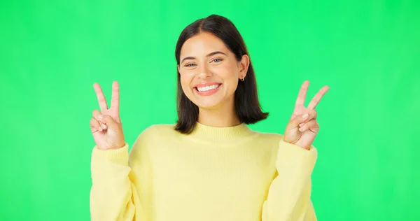 緑の画面 面白い顔の表情と幸せな女性の舌をポーズ 平和のサインと屈託のない人格 ポートレート 女性モデル 笑顔のスタジオで絵文字の反応 ミームと幸福 — ストック写真