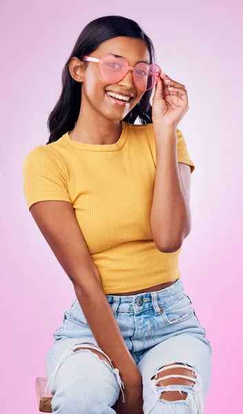 stock image Sunglasses, fashion and portrait of happy Indian woman on pink background with smile, confidence and beauty. Happiness, summer aesthetic and girl in studio with cosmetics, accessories and style.