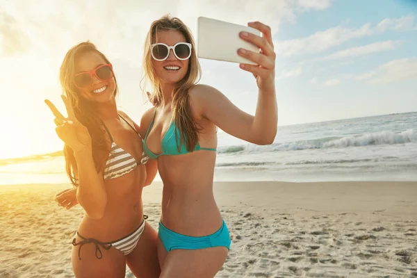 stock image Strike a pose. two friends taking selfies while hanging out at the beach