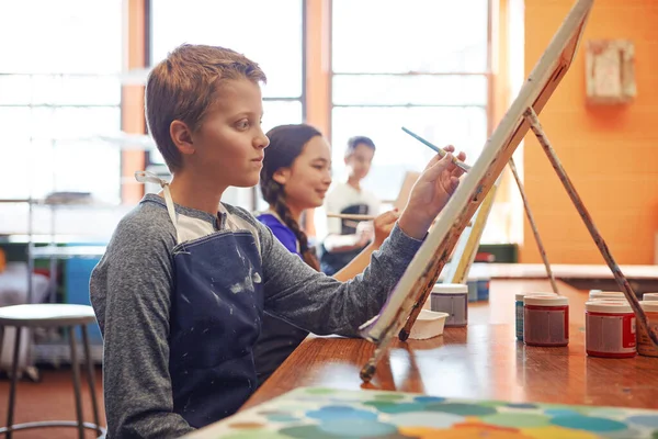 Stock image Learning to express himself creatively. a young schoolboy in an art class