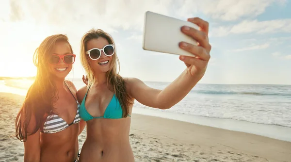 stock image Moments to be remembered. two friends taking selfies while hanging out at the beach